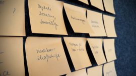 Eine Wand mit Klebezetteln auf denen verschiedene Begriffe stehen, z.B. Nachbarschaftshilfe, Digitale Beratung, Seniorenhilfe, Abstimmungen