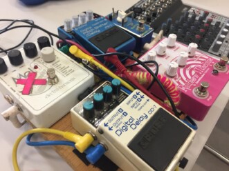 Mehrere Effektgeräte nebeneinander, zum Teil mit mit Wolle ummantelten Kabeln und Tape verändert.