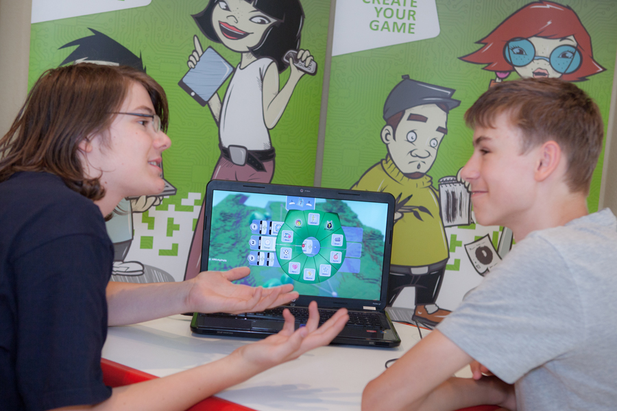 Zwei Jugendliche besprechen Computerspiel vor Laptop