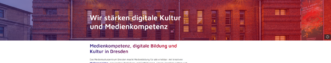 Fassade eines Backsteingebäudes mit weißer Schrift 'Wir stärken digitale Kultur und Medienkompetenz'